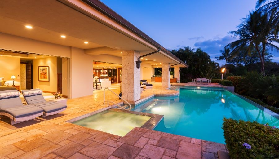 A home with an open-air floor plan and backyard with a pool and spa.