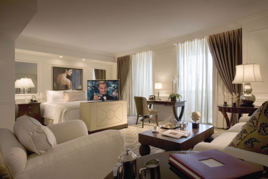  A guest room with soft lighting, elegant draperies, and a hidden TV raised from the foot of the bed.