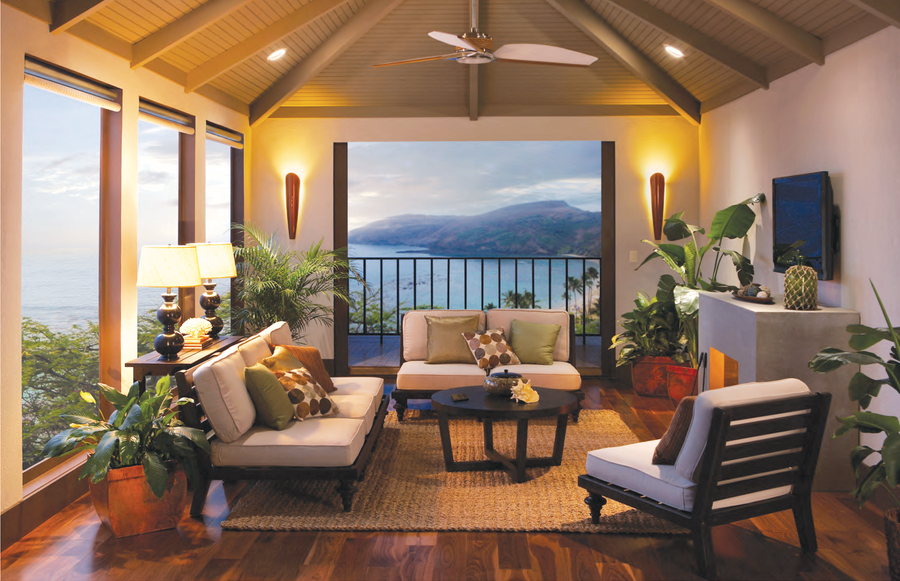  A living room with large windows and motorized shades, looking over a bay and a mountain.