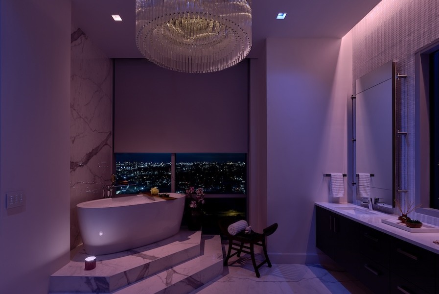 A luxury bathroom illuminated with purple LED light.