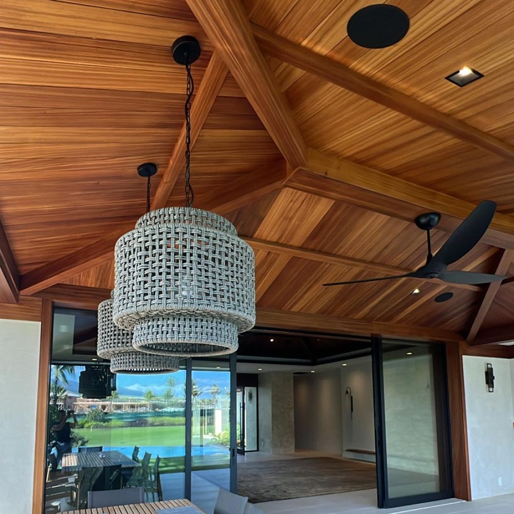 Dining room with long tables, cushioned chairs, and large screens showing a football game